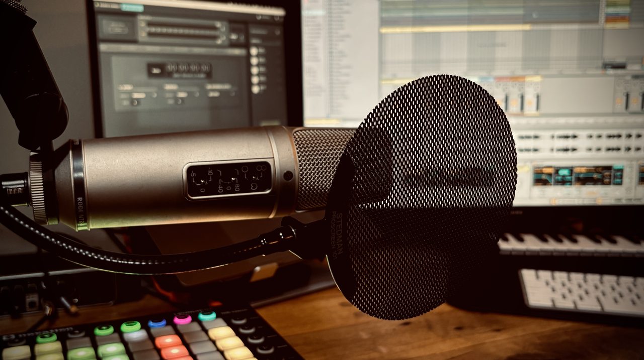 The Clear Signal Voice home studio: condenser microphone with pop screen in front of a DAW session